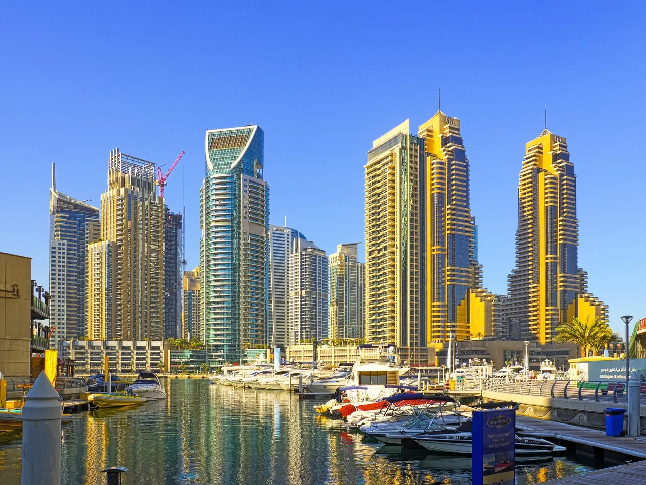 Dubai Marina apartment towers and moored yachts on a sunny day