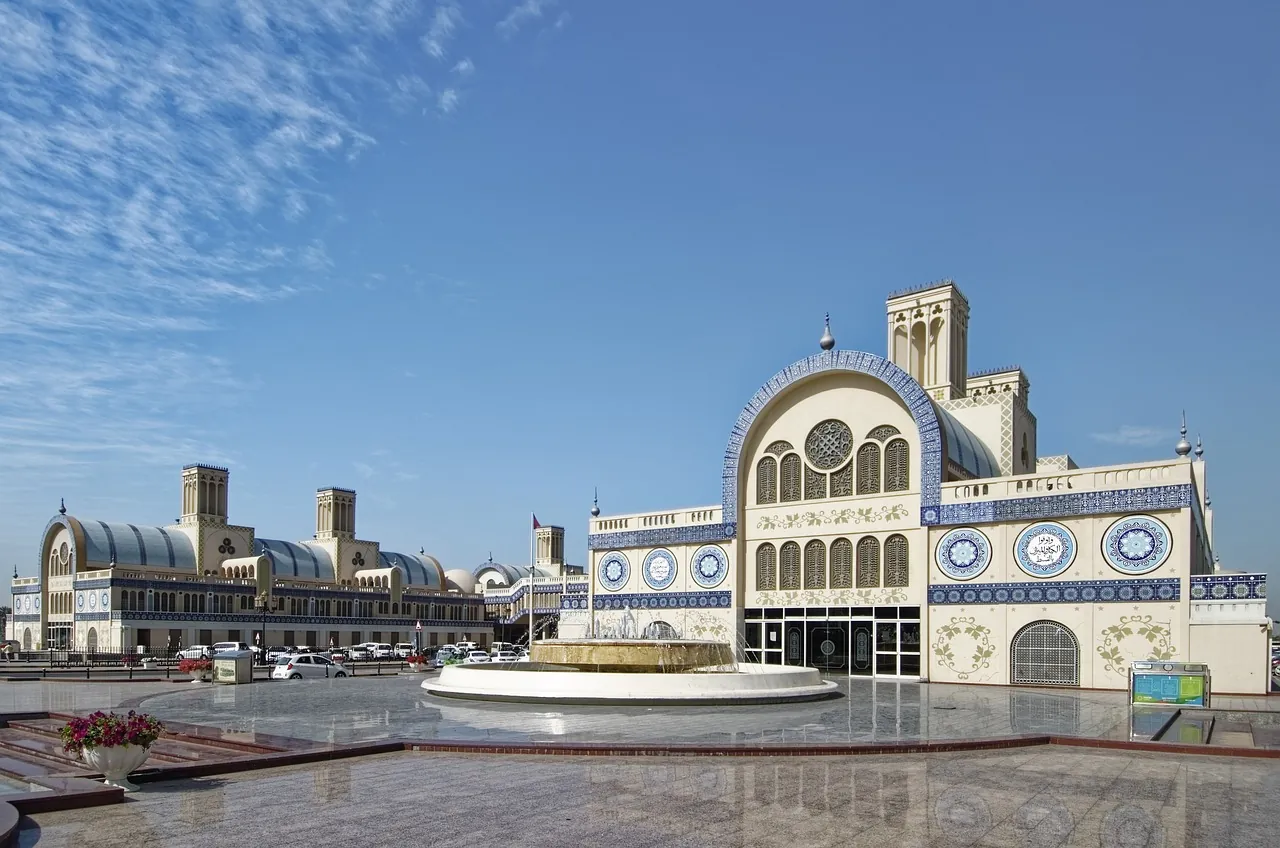 Sharjah's Central Souq, with its blue-tiled arches and wind towers, beside a fountain