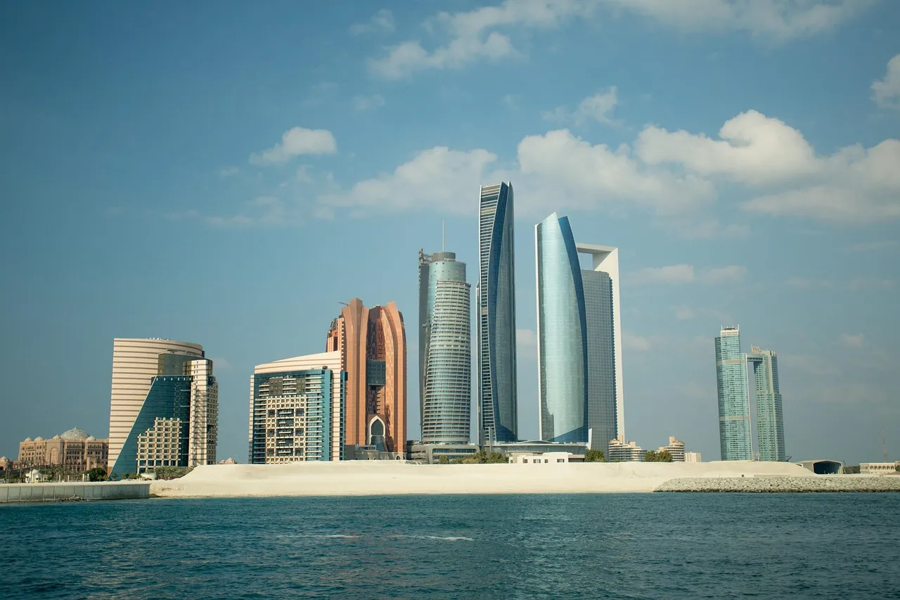 Abu Dhabi towers rising behind a low island waterfront under a clear sky